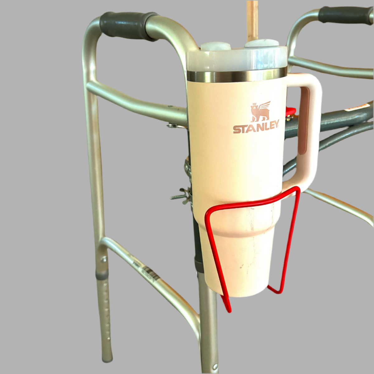 Stanley mug holder attached to a walker with a gray background