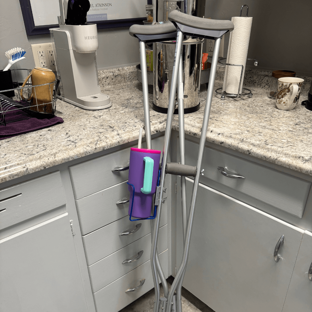 Translation missing: en.Crutch Drink Holder attached to crutches in a kitchen setting, allowing easy access to drinks