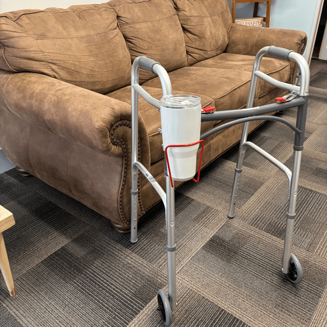 Translation missing: en.walker cup holder aluminum drink holder for walkers attached to a walker beside a brown couch