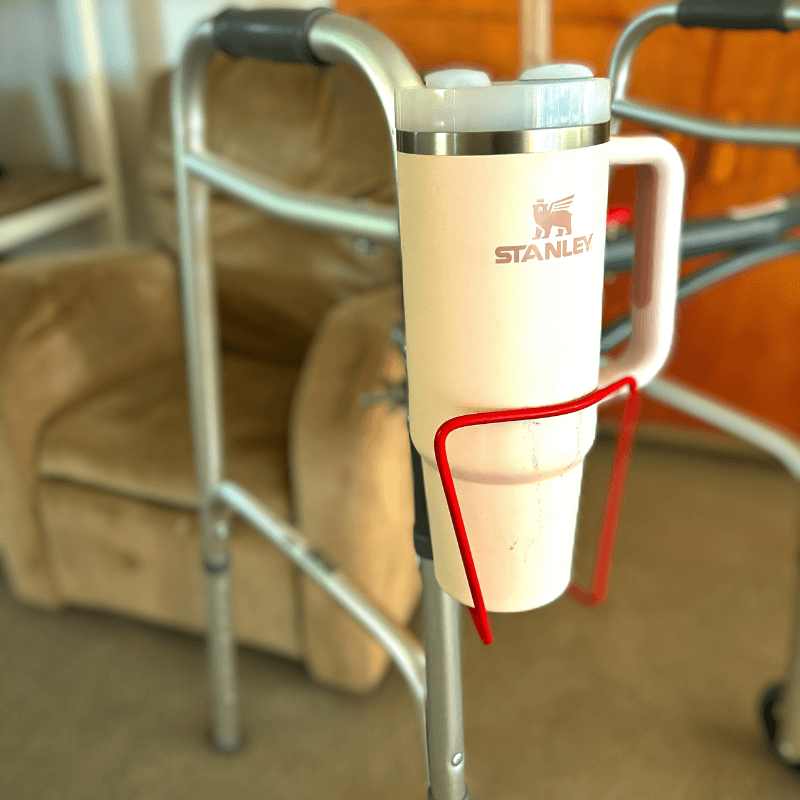 Walker cup holder securely holding a Stanley drink mug, designed for walkers, made of lightweight aluminum for convenience.
