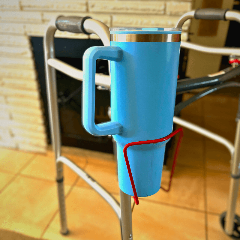 Lightweight aluminum walker cup holder securely holding a blue drink container for hands-free hydration.