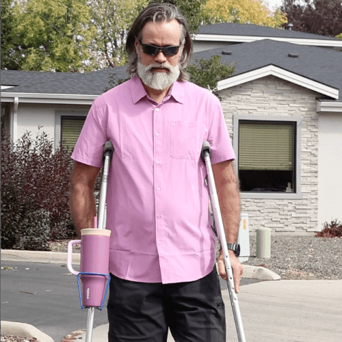 Translation missing: en.Man using Crutch Drink Holder with crutches outdoors, showcasing drink holder design and functionality