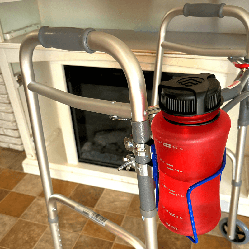 Aluminum walker with a red water bottle secured in a cup holder, showcasing mobility and hydration convenience.